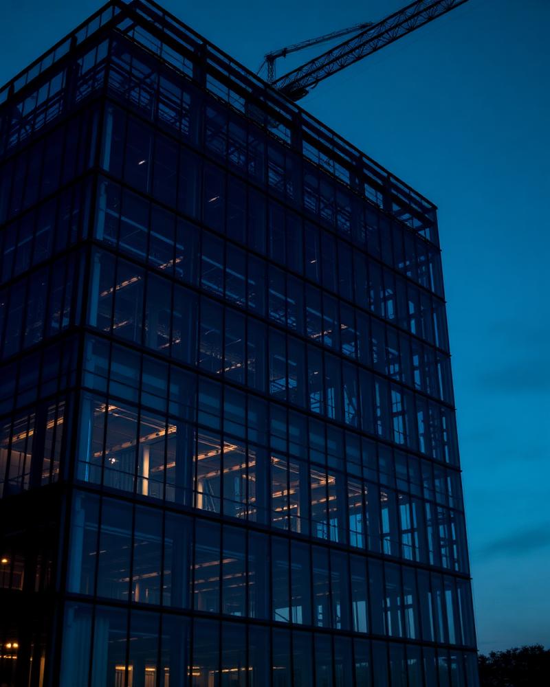 Modern glass building under construction with steel beams